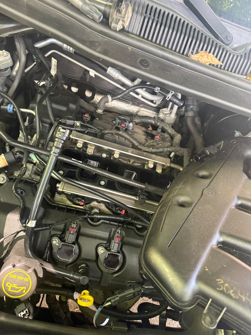V6 engine with the upper intake manifold removed, fuel rails and ignition coils exposed