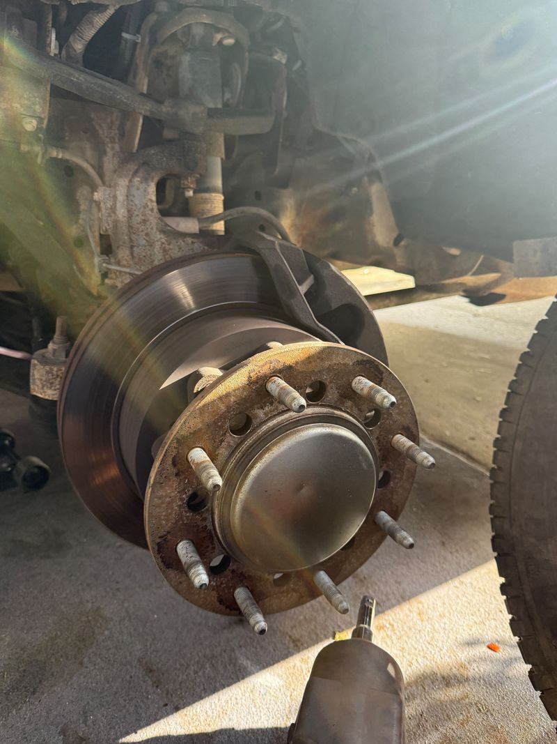 New brake rotor on an 8-lug truck hub with an impact wrench in front